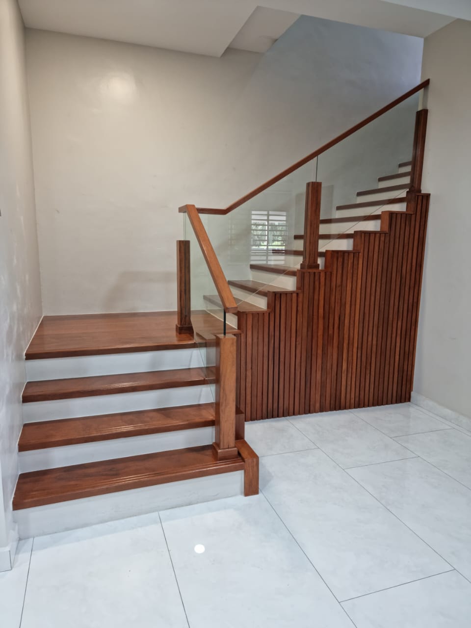 Solid wood staircase with glass balustrade and slat panelling