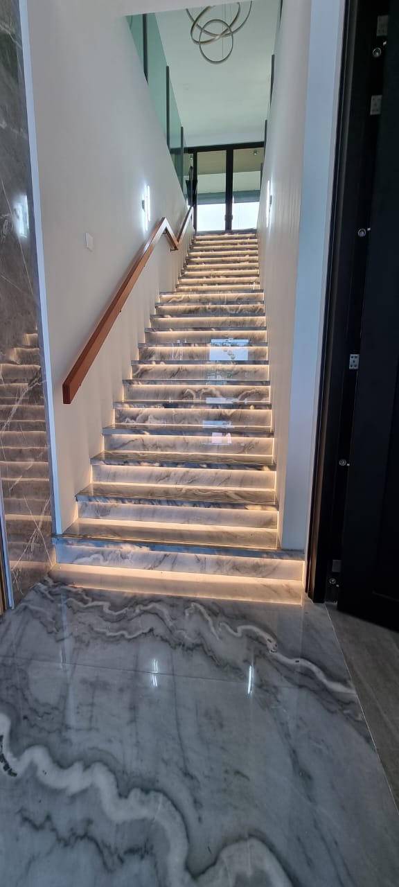 Marble staircase with LED lighting and wood handrail
